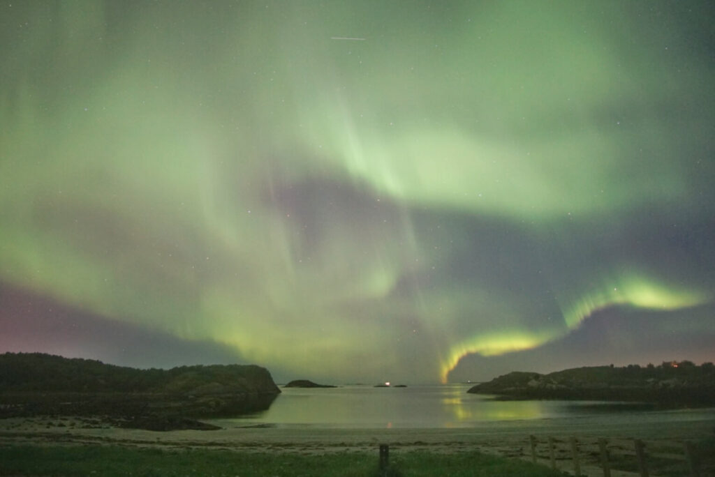 northern lights / aurora borealis over a beach near bodø